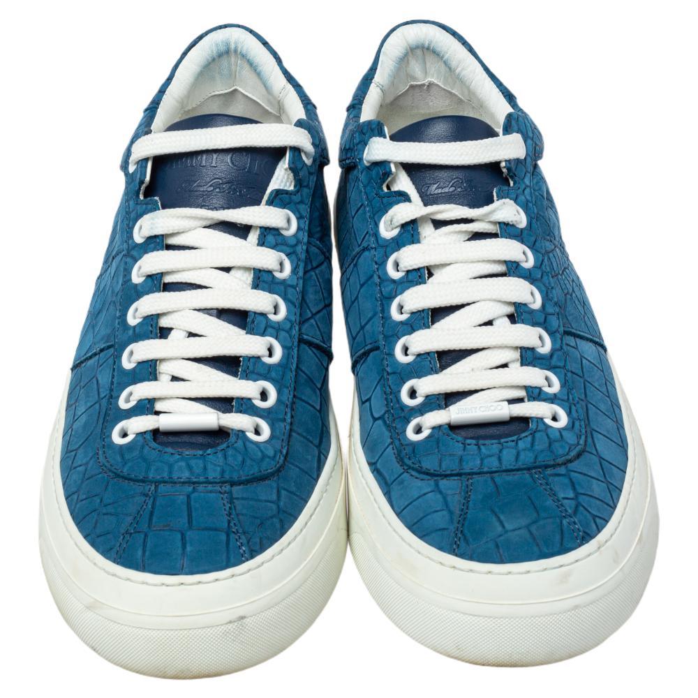 Casual outings will now get a stylish update with these low-top sneakers from Jimmy Choo. The blue sneakers are crafted from croc-embossed leather, detailed with lace-ups, and endowed with comfortable insoles. They are complete with durable rubber