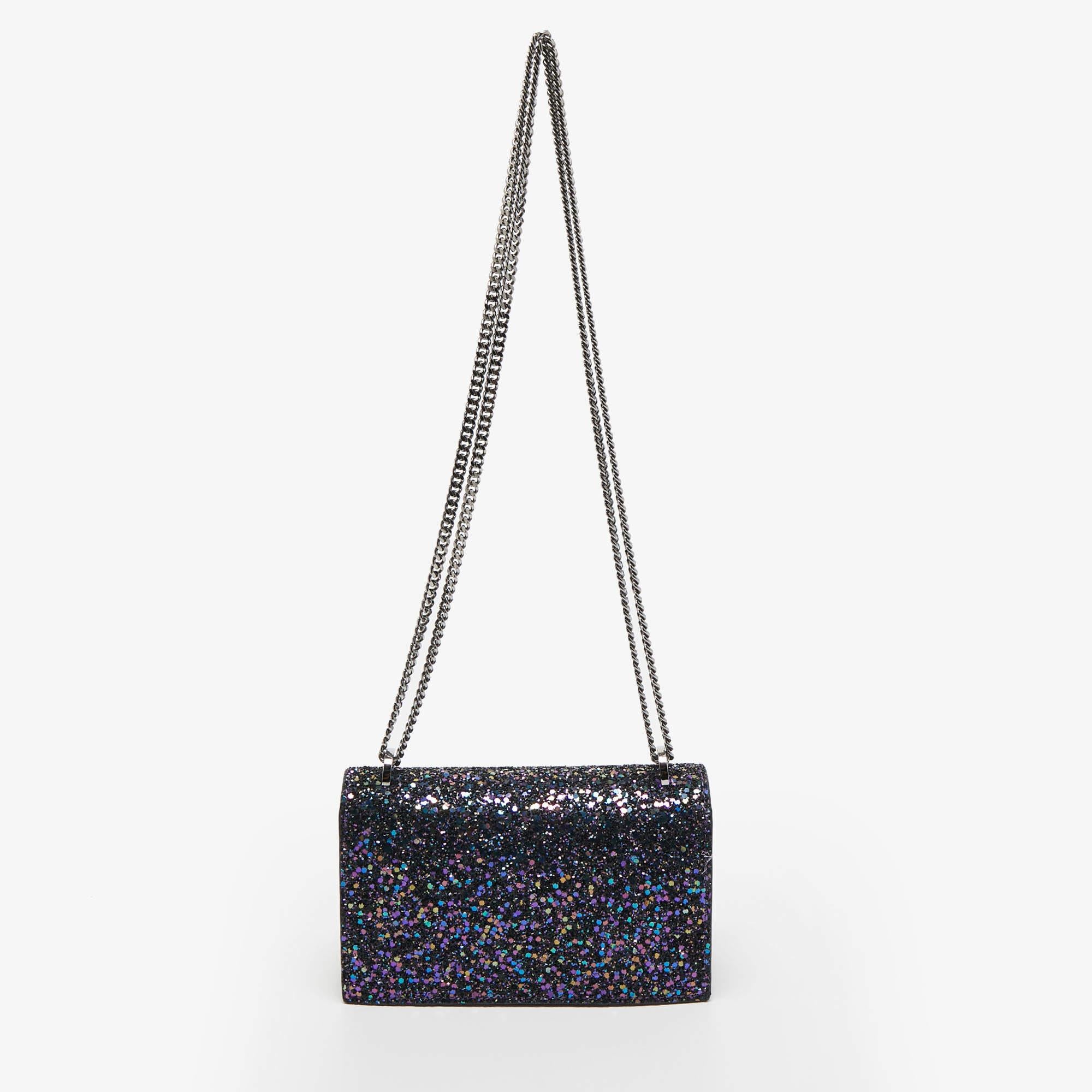 This bag from the house of Jimmy Choo is an accessory you would go to season after season. It has been crafted from glitter fabric into a flap style. It comes with a sliding chain and round tag details on the flap.

