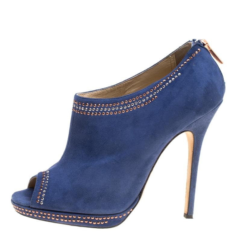 Strut the street wearing these Jimmy Choo ankle booties and leave the bystanders drooling over your style. It is crafted from blue suede with peep toes and is detailed with two-toned stud trims. The pair is complete with zipper closure and