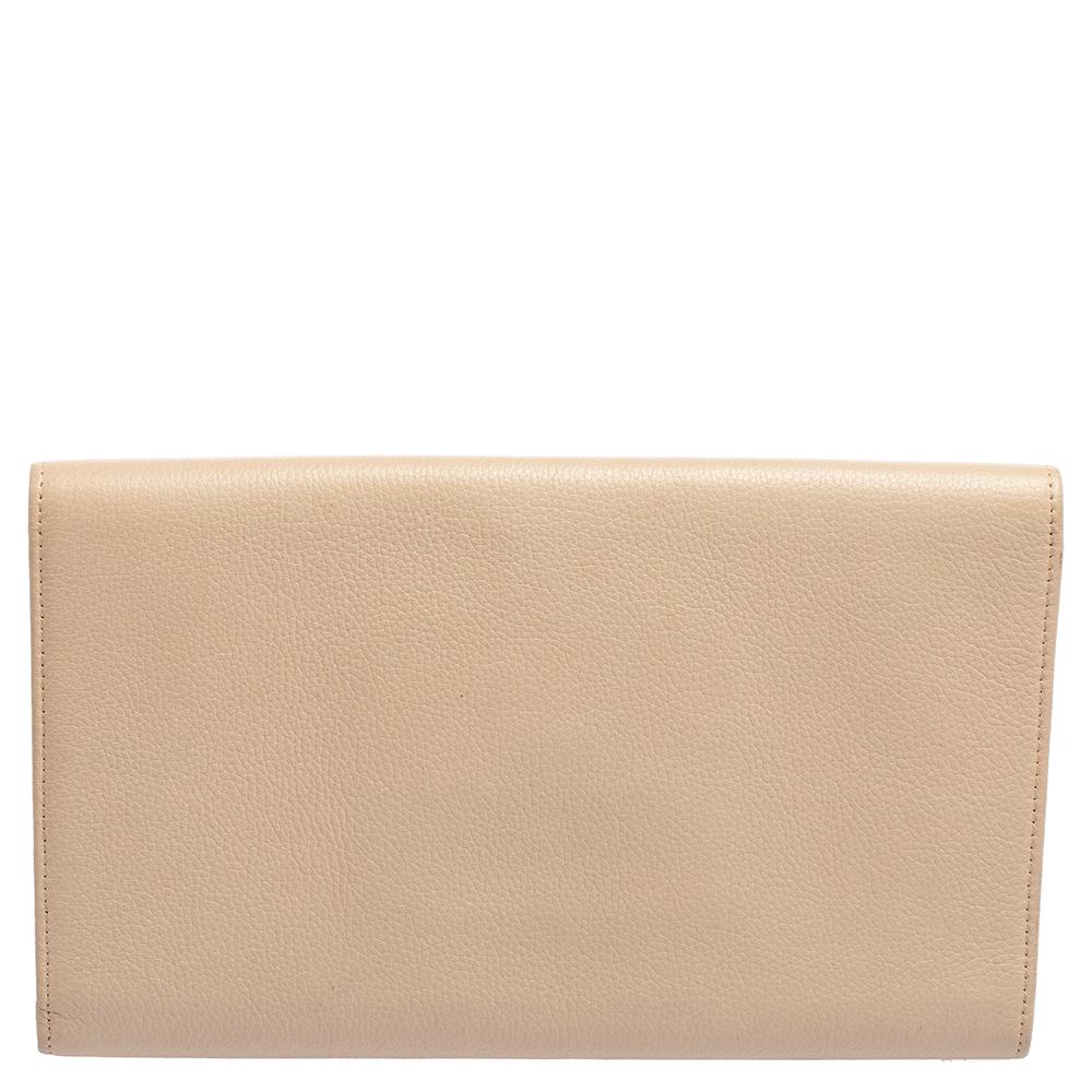 The Jimmy Choo Reese Clutch is both practical and glamorous. Crafted from blush pink leather, this Italian-made wallet is presented in a streamlined silhouette. The facing flap with a gleaming logo plaque opens to a fabric interior with card holder