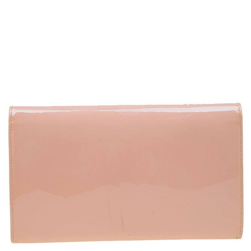 The limited edition Jimmy Choo Reese Clutch is both practical and glamorous. Crafted from smooth and glossy blush pink patent leather, this Italian-made wallet is presented in a streamlined silhouette. The facing flap with a gleaming logo plaque