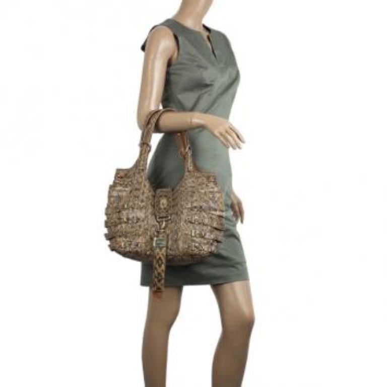 This stylish tote by Jimmy Choo is a rare accessory to own. It is crafted from crinkled snakeskin leather and features decorative studded buckle straps with large leather tab key chain, fold-over tab with turnlock closure, double shoulder straps and