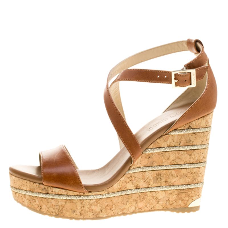 Jazz up your evening parties or outings with these Jimmy Choo leather wedges. Designed in subtle contemporary hues, these sandals feature criss-cross buckled straps over the ankle giving a good hold of the foot. It is open from the toe area giving