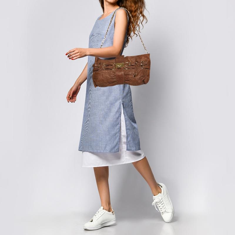 Own this gorgeous Jimmy Choo Riki bag today and light up your closet! Crafted from leather, this stunning number has a flap top with a signature lock and a spacious Alcantara interior. It also features a chainlink shoulder strap, gold-tone hardware,