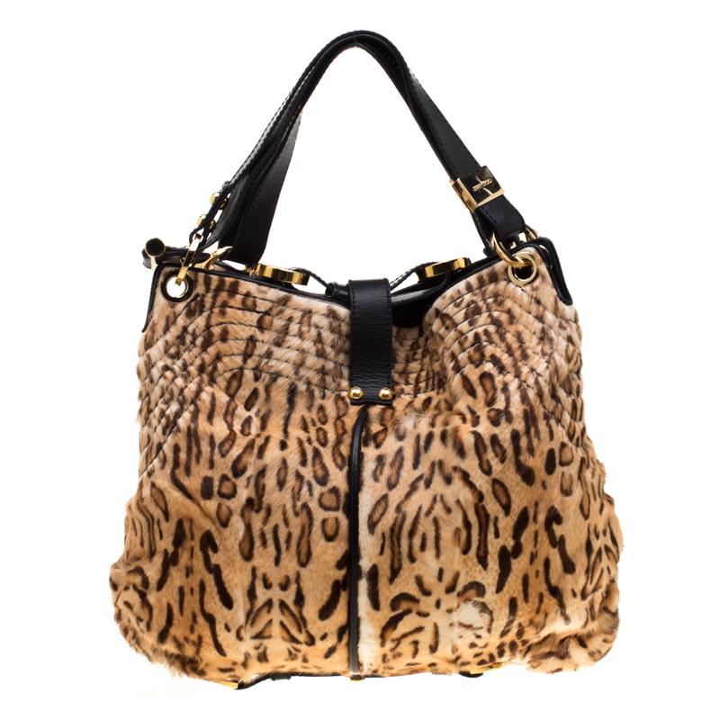 Own this gorgeous Jimmy Choo tote today and light up your closet! This gorgeous bag is crafted from brown leopard-printed calf hair and it carries black leather trims on the exterior. The piece is equipped with a well sized suede-lined interior and