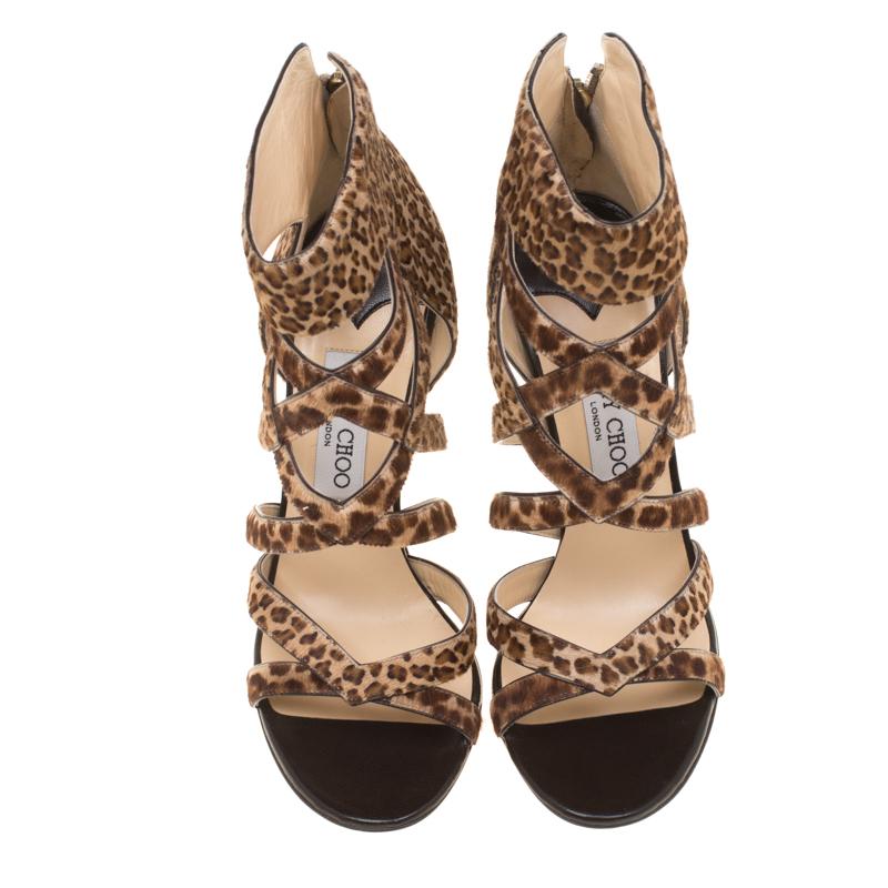 Preparati a fare un'uscita alla moda con questi favolosi sandali Jewell di Jimmy Choo! I sandali marroni sono realizzati in pelle di vitello con stampa leopardo e presentano una silhouette aperta in punta. Sfoggiano un design a gabbia sulla tomaia e