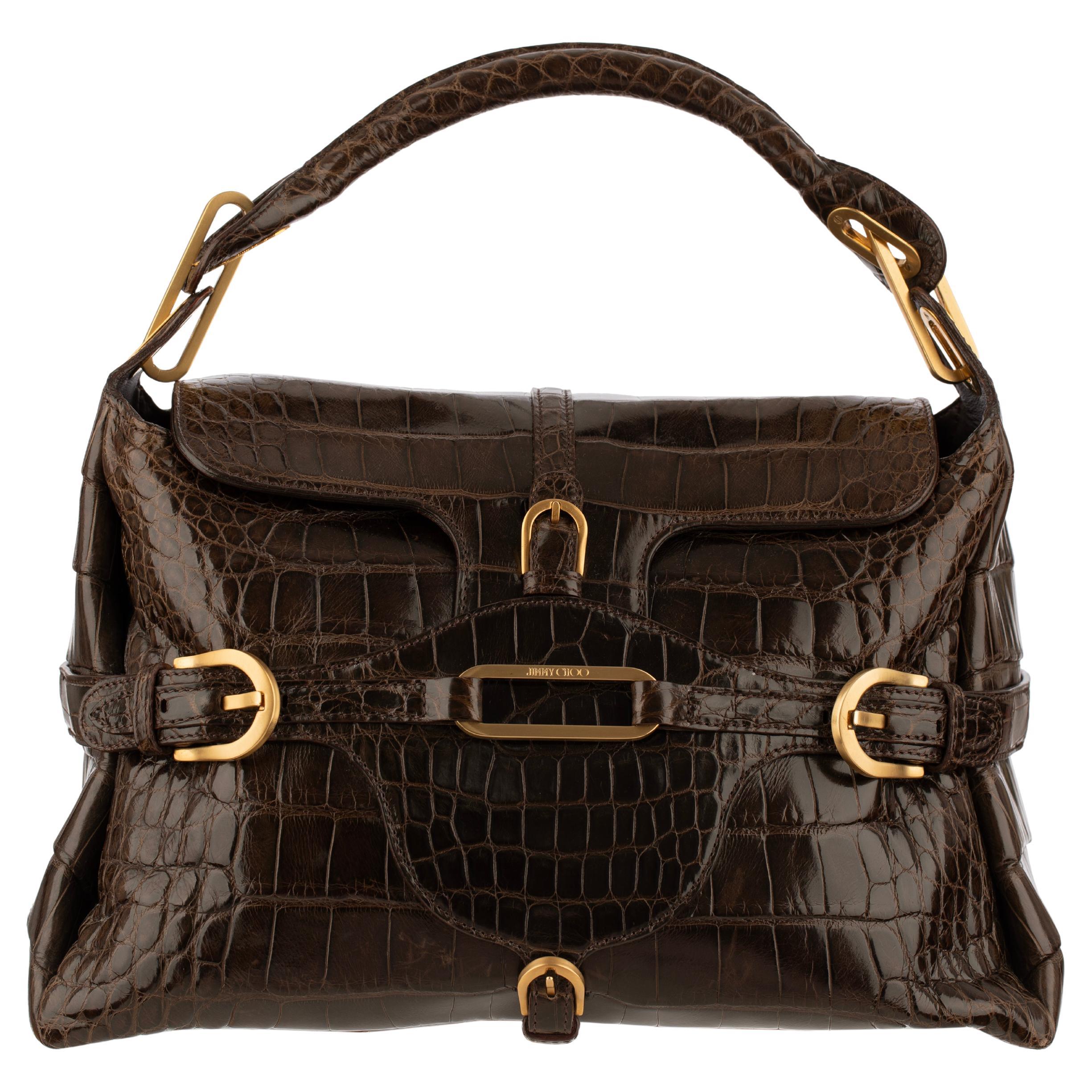 A rare vintage Jimmy Choo Tulita bag in glossy crocodile leather with gold-tone hardware. An iconic early 2000s silhouette featuring a belted front flap, structured top handle, and rich chocolate brown finish—highly collectible and rarely seen in