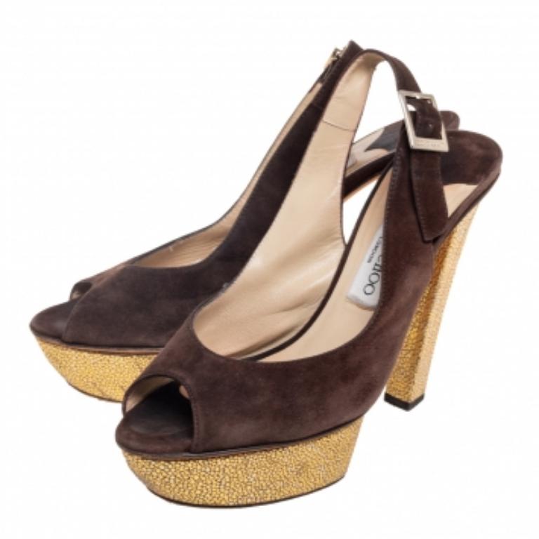 Ces sandales à plateforme Lexy de Jimmy Choo, d'une belle couleur marron, vous feront chavirer de bonheur ! Elles sont confectionnées en daim et présentent une silhouette peep-toe. Ils sont dotés de fermetures à boucle en métal doré, de semelles