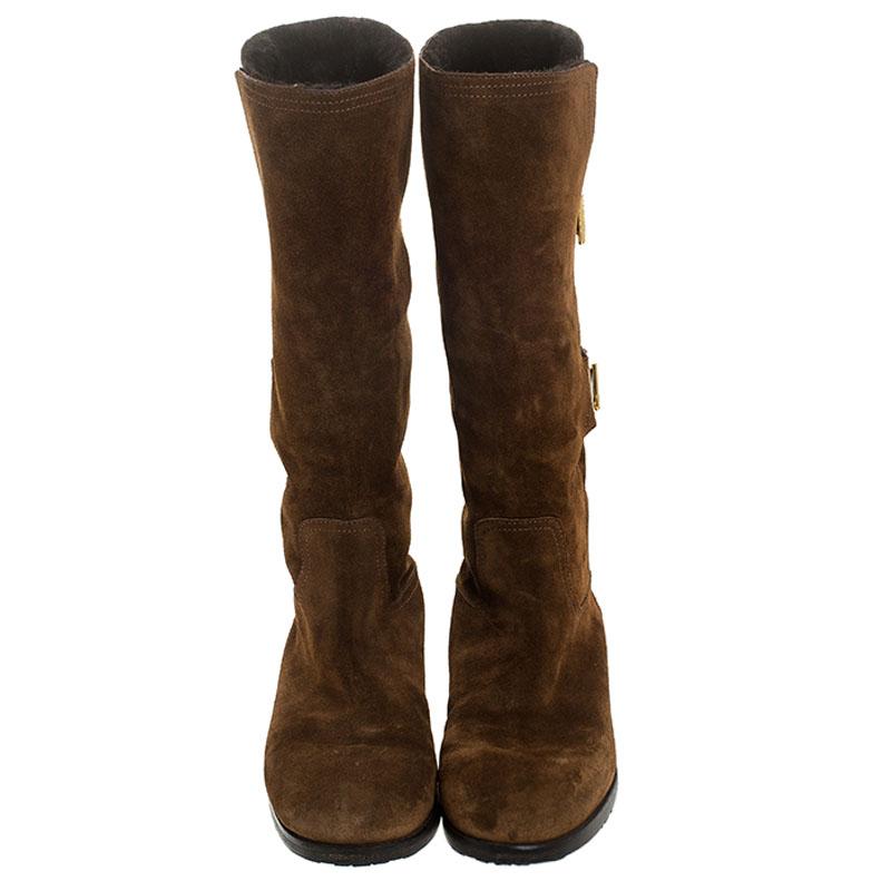 Stay on style with this pair of comfortable brown boots from Jimmy Choo! Beautifully crafted from suede, these mid-calf boots carry round toes, fur lining and toggle strap details. Waltz through winter in this lovely pair!

