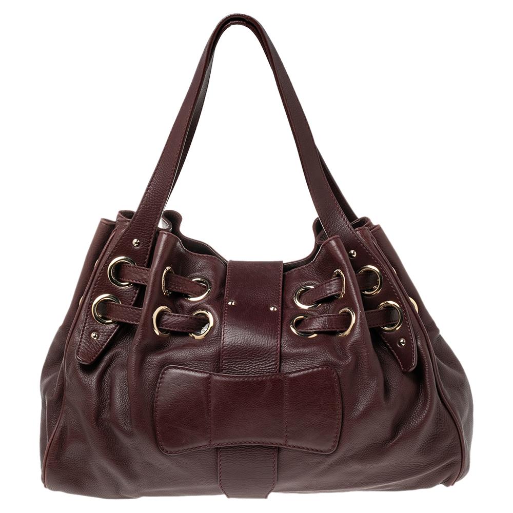 The popular Ramona is another perfectly designed, practical handbag from Jimmy Choo. Crafted from leather, it is accented with double straps, a flip-lock closure, and dual shoulder handles. The interior is lined with Alcantara and features a zip