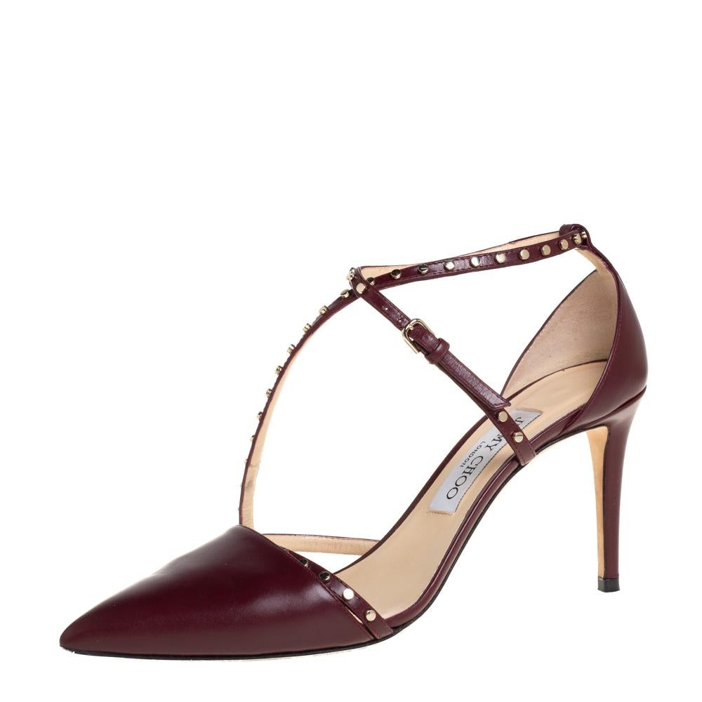 Gleaming in burgundy leather, these Tiff pumps from Jimmy Choo are designed with studded straps, buckle fastening, comfortable insoles, and 8.5 cm heels. They'll complement your formals as well as casuals.

Includes: Original Box