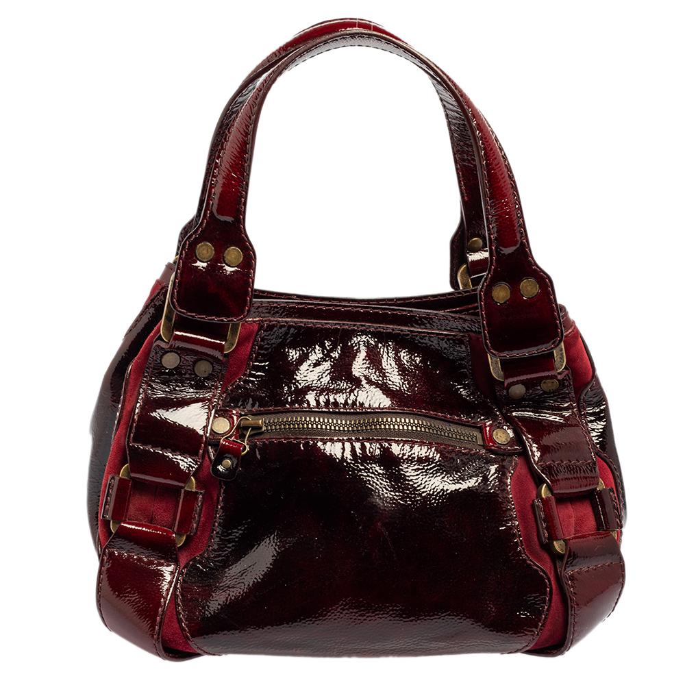 The house of Jimmy Choo has exclusively fashioned this amazing Mahala satchel for you. Crafted from patent leather and suede, the bag features two handles and zip detailing on the front. The suede-lined interior is spacious enough to house all your