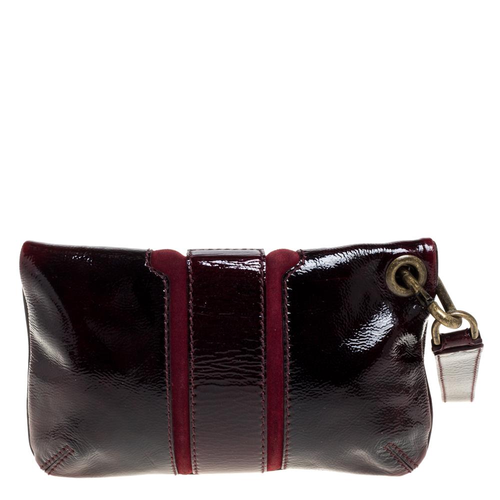 This Mave clutch from Jimmy Choo has a lovely burgundy sheen that will be sure to give shine to any outfit. With a flat leather wrist strap fastened to the bag, this bag has a zip fastening fold-over top and a zip pocket. The front of the clutch has