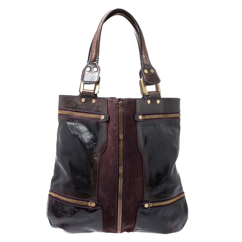 This keep it all bag from the fashion label Jimmy Choo is uniquely designed. Crafted from patent leather and suede, this burgundy bag features zip pocket designs, rolled handles and the brand's label on the exterior. The spacious bag opens to a