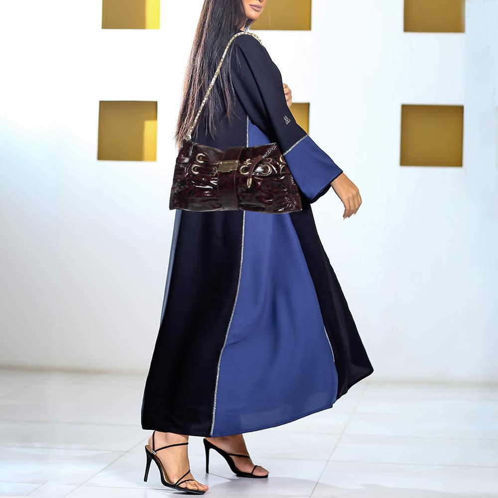 The Jimmy Choo metallic silver Rio clutch is a glamorous bag that can go from day to night with style and ease. Crafted from patent leather it features gorgeous gold tone metal accents leather straps that lace through metal eyelets and a chain