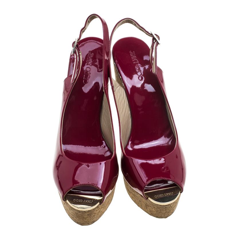 These lovely Prova sandals from the fashion house of Jimmy Choo will be your ideal companion for casual or formal outings. Crafted from cherry red patent leather, they feature peep toes, gold-tone metal toe tips with the brand detailing, and