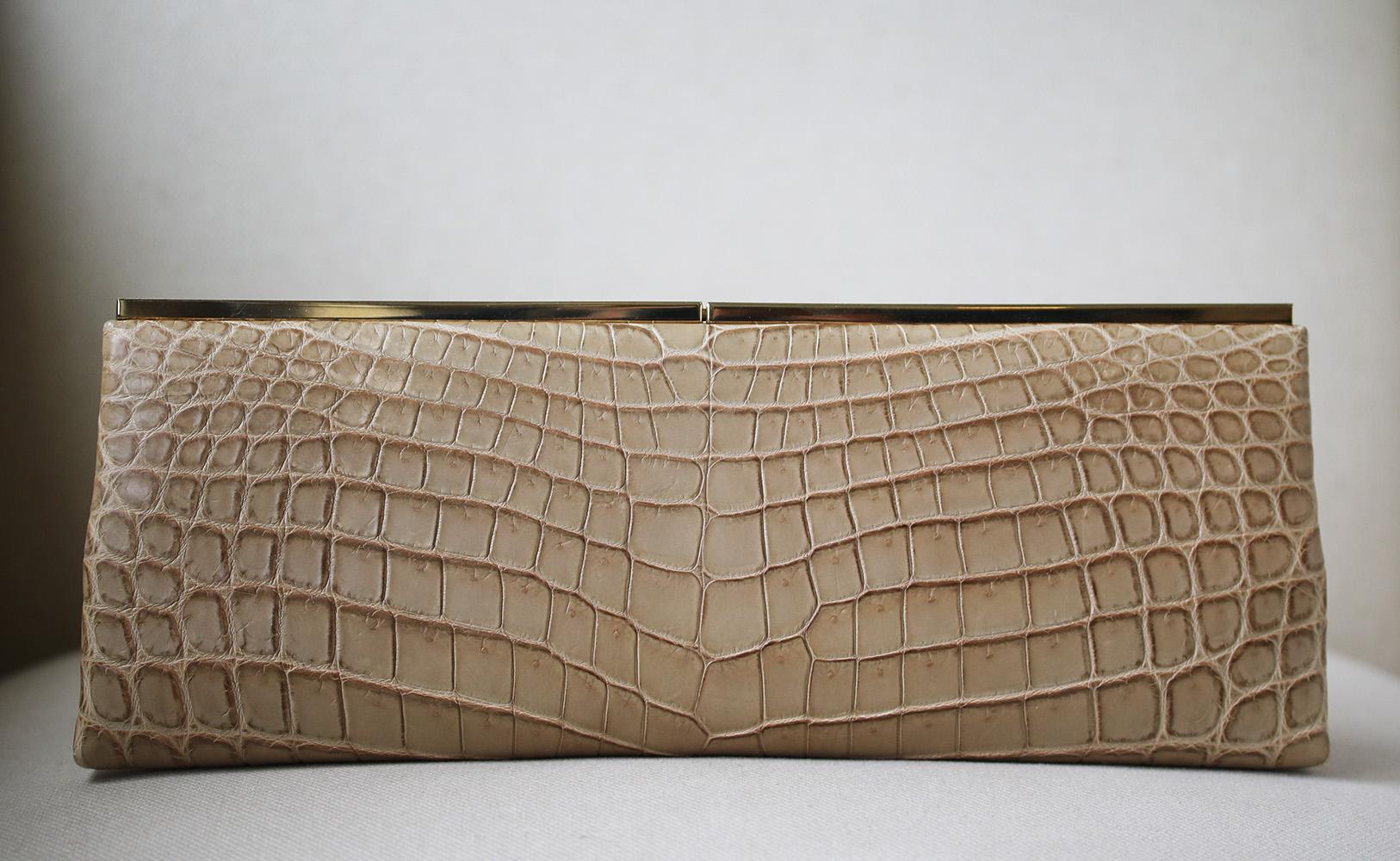 Beige croc-effect leather clutch from Jimmy Choo featuring a rectangular shape, a gold-tone opening, a press clasp fastening, an interior patch pocket and a cream leather lining. Does not come with dustbag.

Dimensions: 13 x 5 x 1 inches

Condition: