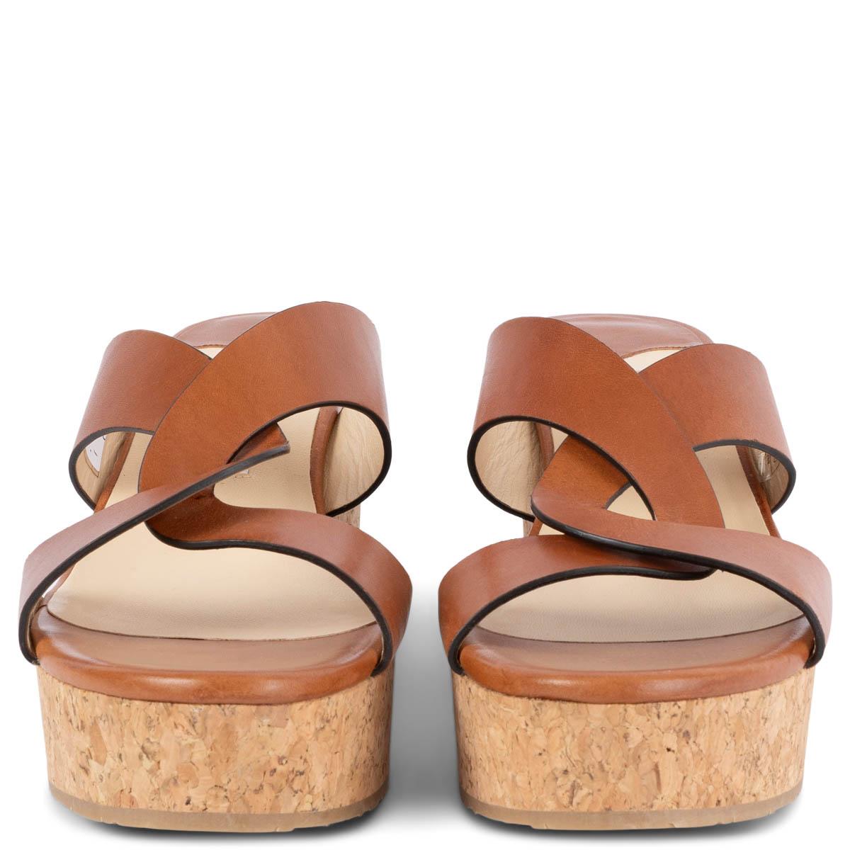100% authentic Jimmy Choo Atia 75 cork wedge mules with cognac brown twisted leather strap detail. Have been worn and are in excellent condition. 

Measurements
Imprinted Size	40
Shoe Size	40
Inside Sole	26.5cm (10.3in)
Width	8cm (3.1in)
Heel	8cm