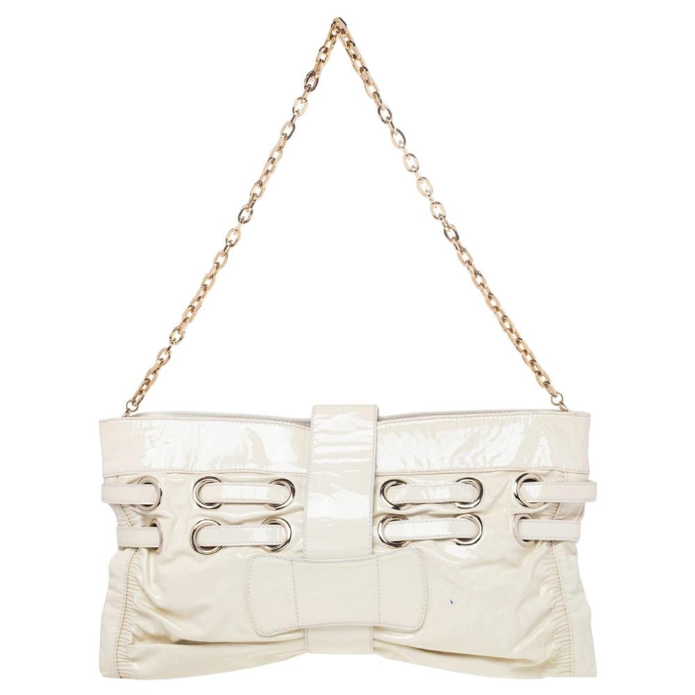 The Jimmy Choo Rio shoulder bag is a glamorous creation that can go from day to night with style and ease. Crafted from patent leather, it features gorgeous gold-tone metal accents, patent leather straps that lace through metal eyelets, and a