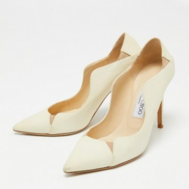 Faites chaque pas avec élégance et style avec ces escarpins Tamika de la maison Jimmy Choo. Ils sont fabriqués méticuleusement avec du cuir texturé crème sur l'extérieur. Elles sont dotées de bouts pointus, d'un détail d'enfilage et de talons