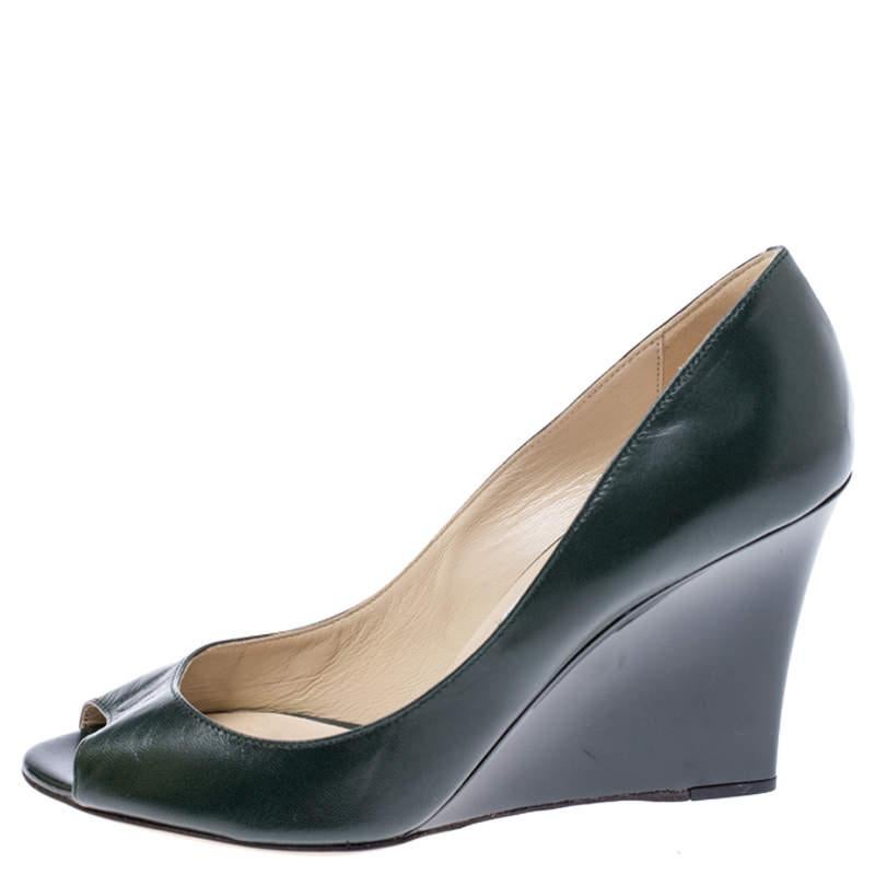 These exquisite Jimmy Choo Baxen pumps will bring just the right amount of height to daytime looks. Crafted in dark green leather  they feature classic peep toes  leather insoles and wedge heels for all day comfort.