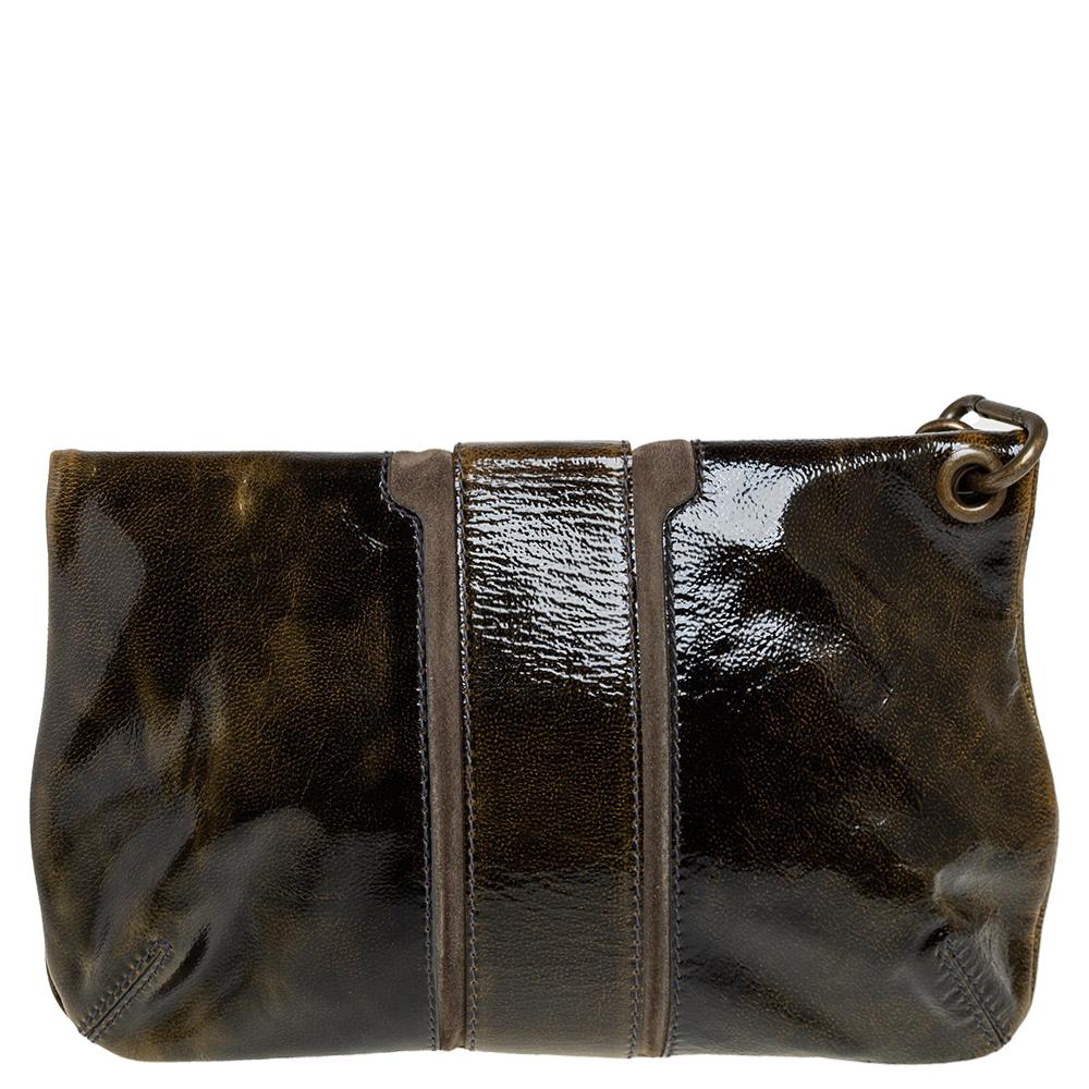 This Mave clutch from Jimmy Choo has a lovely dark green hue that will be sure to give shine to any outfit. With a flat wrist strap fastened to the bag, this patent leather bag has a zip fastening fold-over top and a zip pocket. The front of the