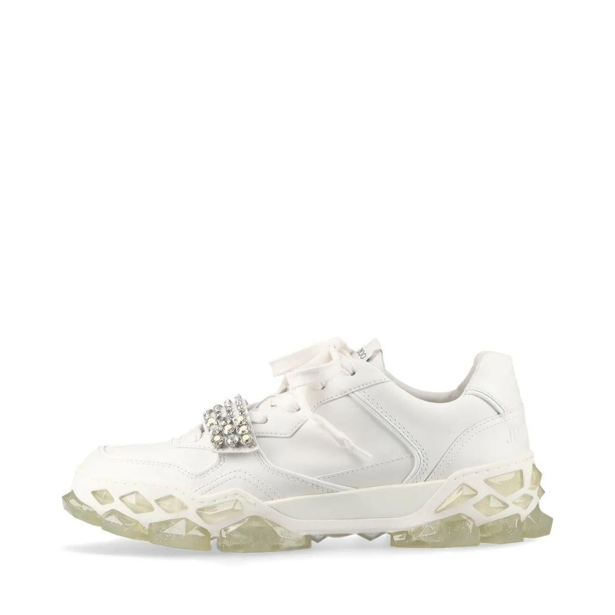 The Jimmy Choo Diamond Leather Sneaker Unisex in White is a luxurious fusion of sporty design and glamorous detail. Crafted from smooth, high-quality leather, the sneaker features a sleek, minimalist silhouette elevated by a striking rhinestone