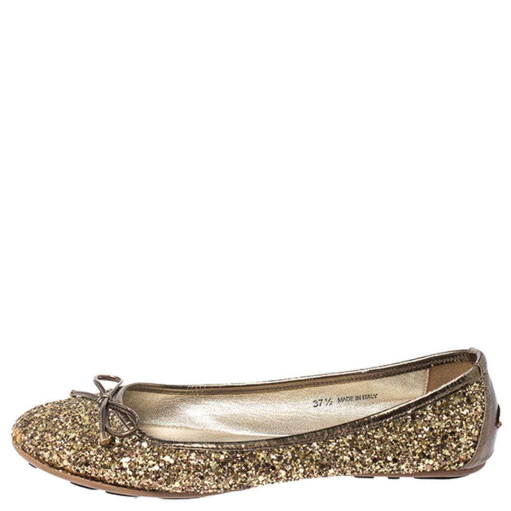 These sparkling ballet flats by Jimmy Choo are a must-have. Crafted from gold glitter fabric, they feature round toes, bow detailing on the uppers, leather lining, insoles and soles. They are finished with the brand logo appearing on the counters.