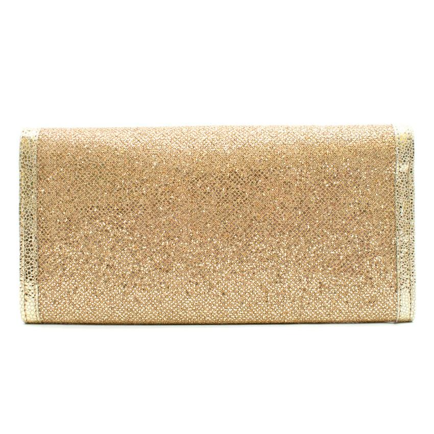 immy Choo gold glitter clutch

- Gold, glitter lame 
- Gold leather-trimmed edges and flap panel 
- Push-stud fastening front flap, logo-engraved gold-tone  metal plaque 
- One compartment, one zip and slip pocket, twelve card slots
- Gold faille