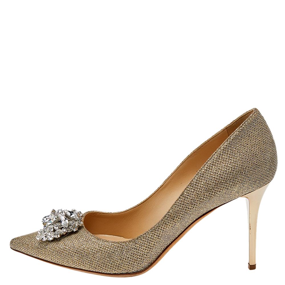 Let your style shimmer with these pumps from Jimmy Choo! Beautifully crafted from lamè glitter fabric, they feature pointed toes, 9 cm heels, and crystal embellishments on the uppers. You're sure to love owning this gorgeous pair.