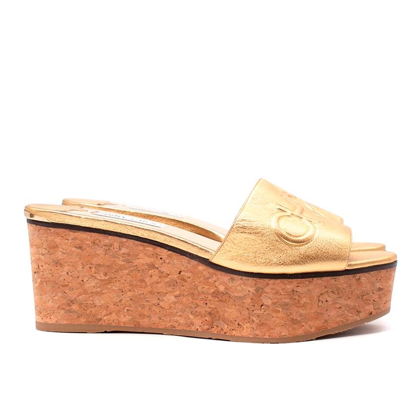 Jimmy Choo Gold Leder Deedee 80 Kork-Keilsandalen
 

 - Gestufter Kork-Keilabsatz
 - Obermaterial aus goldfarbenem Leder mit Choo-Prägung
 

 Materialien 
 100% Leder 
 100% Kork 
 

 Hergestellt in Spanien 
 

 BITTE BEACHTEN SIE, DASS ES SICH BEI