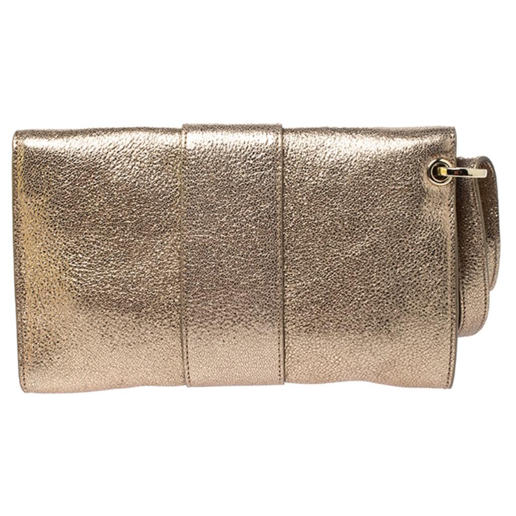This stunning Rebel clutch by Jimmy Choo is designed to deliver glamour and style. Crafted from leather, it comes in a lovely shade of gold. It has a front flap with a gold-tone closure that opens to a suede-lined interior with a zip pocket that
