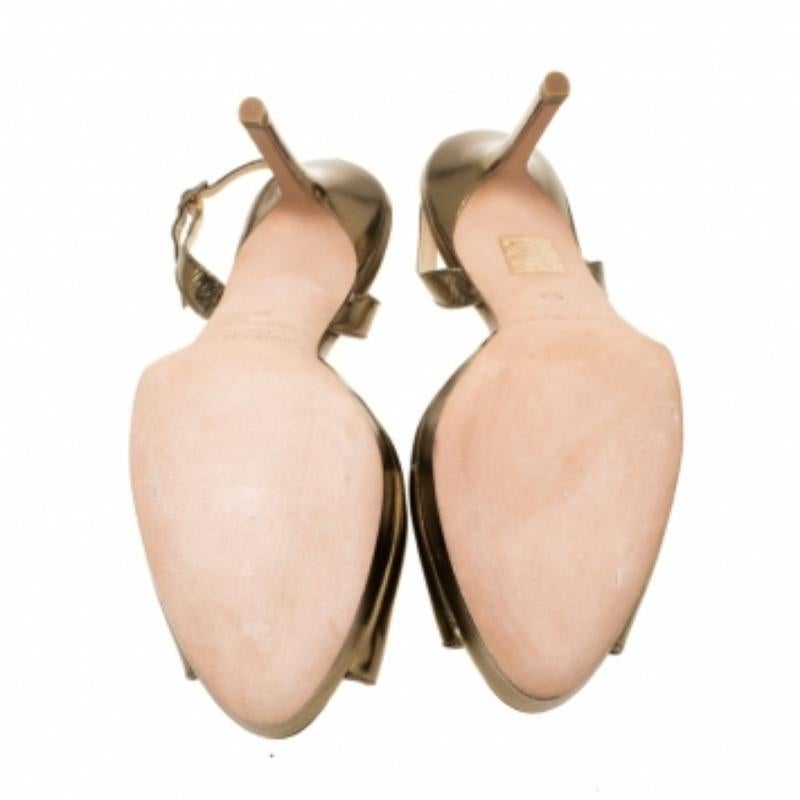Indossa questi sandali Jimmy Choo e aggiungi grazia ai tuoi passi. Realizzate in pelle verniciata oro, hanno la punta aperta, la fibbia e il tacco di 10,5 cm. Questi sandali dorati daranno una sensazione di lusso ai tuoi piedi.