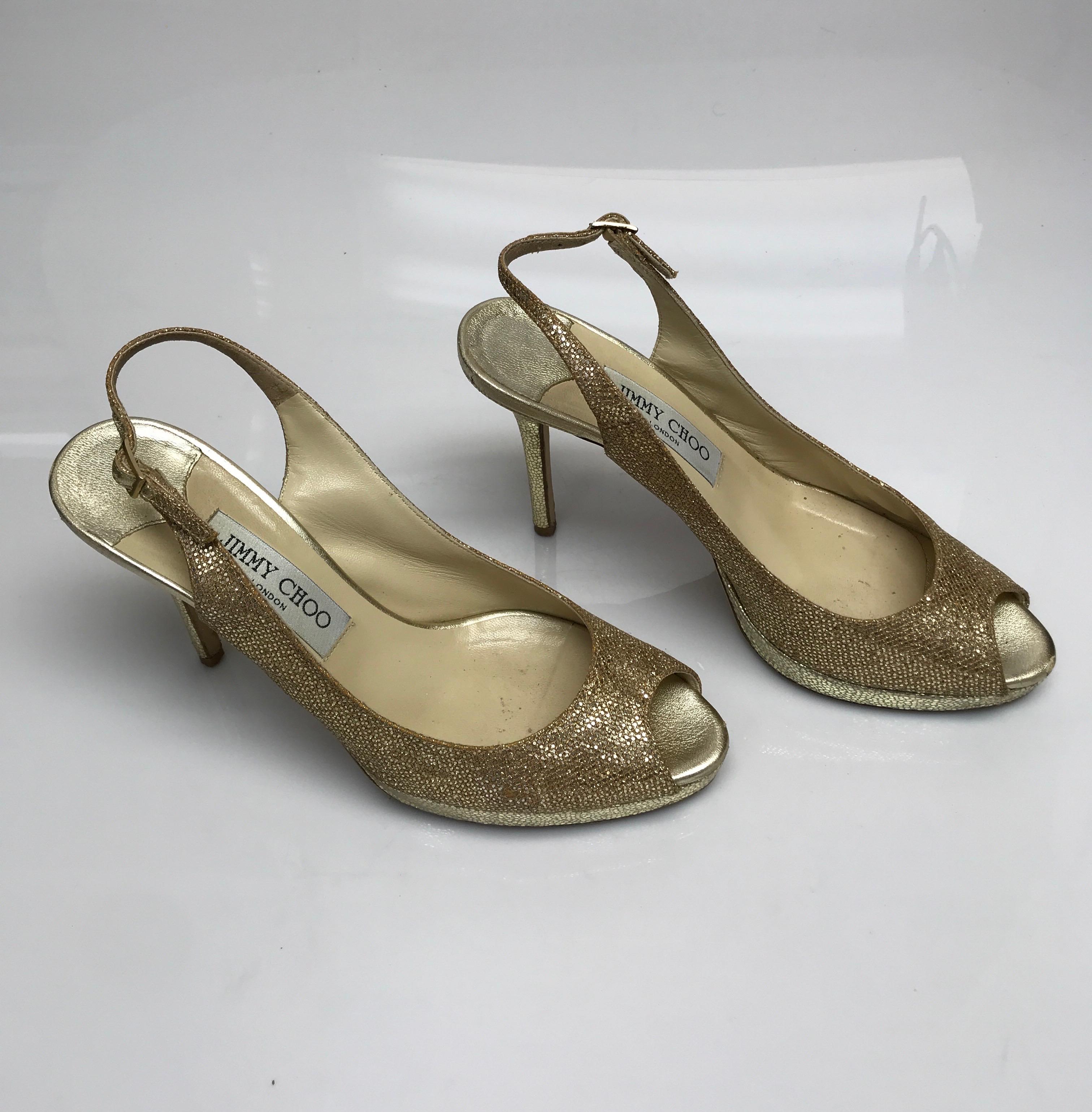Jimmy Choo Gold Peeptoe Heels-38. These elegant Jimmy Choo heels are in good condition. They show some sign of use to the bottom sole of the shoes and few sequins missing throughout. These shoes are gold textured throughout and have a peeptoe design