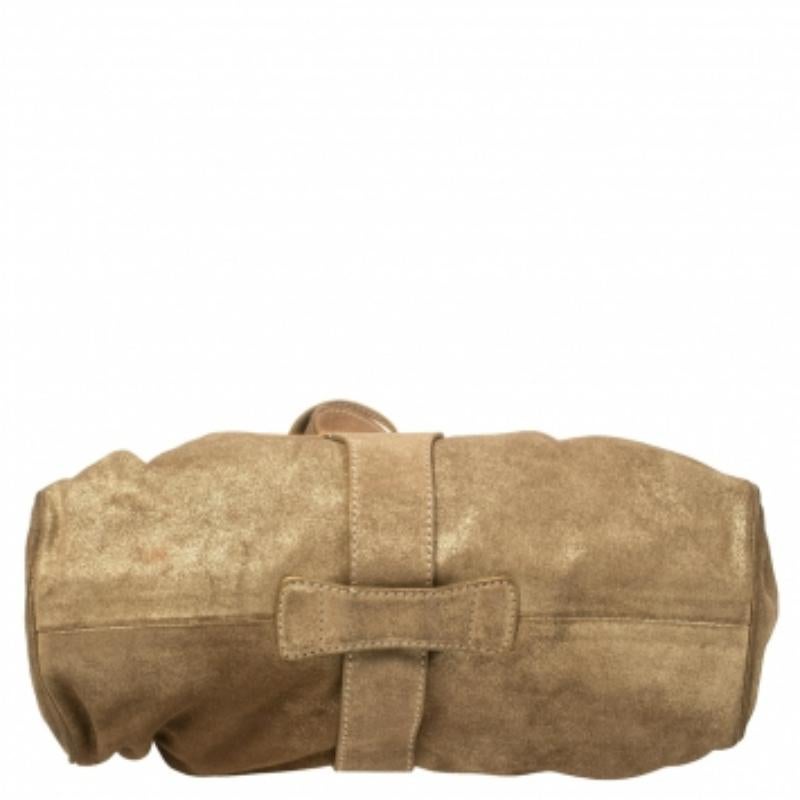 The popular Ramona is another perfectly designed, practical handbag from Jimmy Choo. Crafted from gold shimmer suede, it is accented with double straps, a flip-lock closure, and dual shoulder handles. The interior is lined with suede and features a
