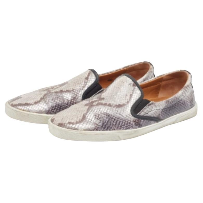 Desprende encanto y sofisticación al caminar con estas zapatillas de la Casa Jimmy Choo. Están diseñadas con cuero repujado en pitón en el exterior.