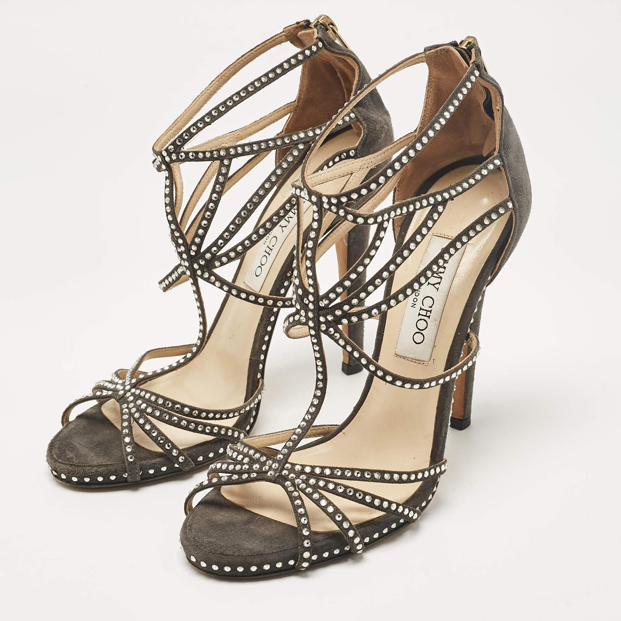 Ornée de superbes ornements en cristal, cette pièce grise de Jimmy Choo est confectionnée en daim et présente une silhouette à brides, complétée par des fermetures à glissière sur les contreforts. Les ornements en cristal sur la pièce et les talons
