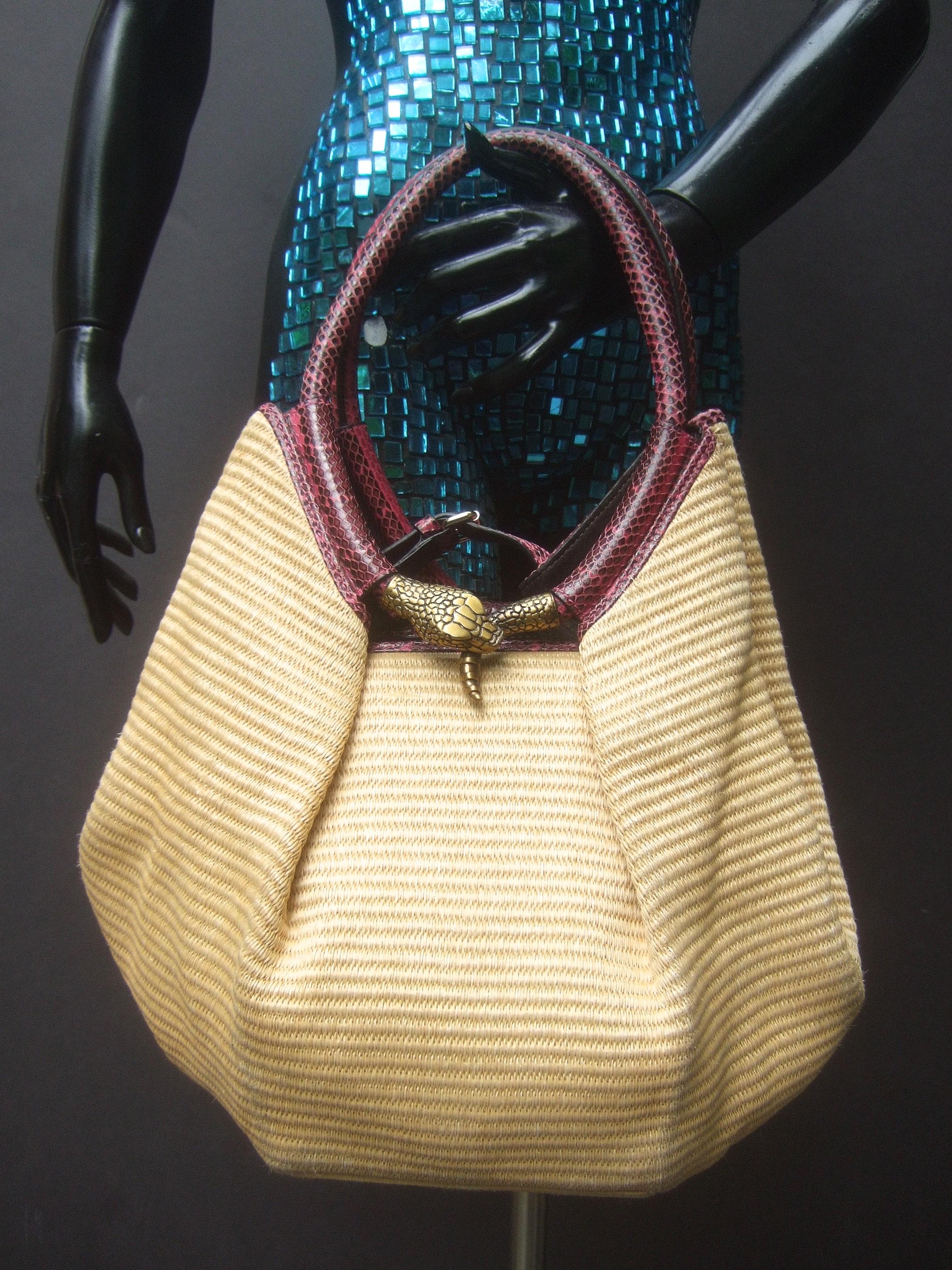 Jimmy Choo Italian straw raffia brass metal serpent medallion handbag c 1990s
The unique Italian handbag is constructed with natural color intricately woven straw raffia bands
Carried with embossed fuchsia pink with darker shades of pink oval-shaped