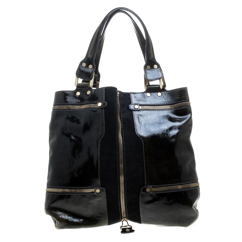 Easily shift from day to night with this one in functional patent leather exterior detailed with a suede panel and chain accents making this Jimmy Choo creation a premium design. As magnificent and rare it looks from outside, it has an equally