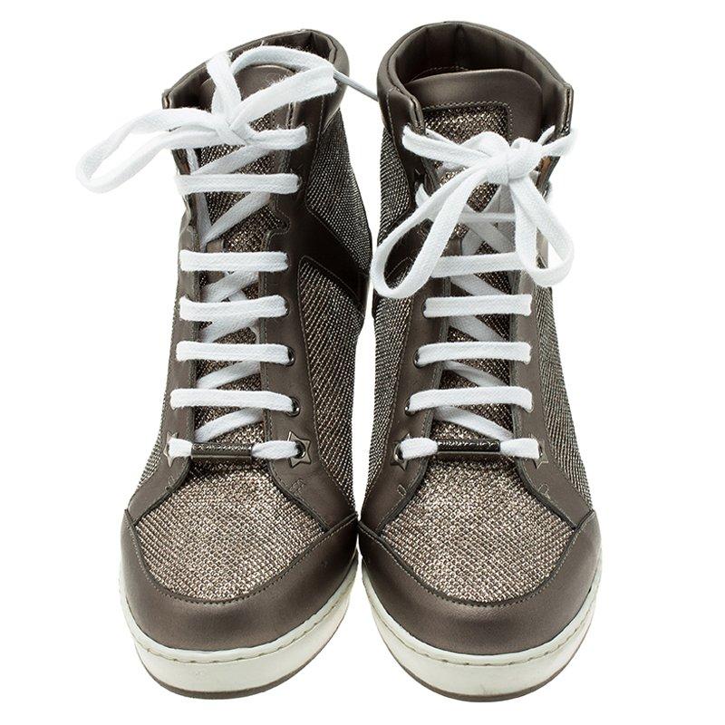 These Jimmy Choo Preston Panama Wedge sneakers are characterized by contemporary styling. Crafted from the combination of lame glitter and metallic leather, these sneakers have white laces along the shoe arches and star engraving on the soles.