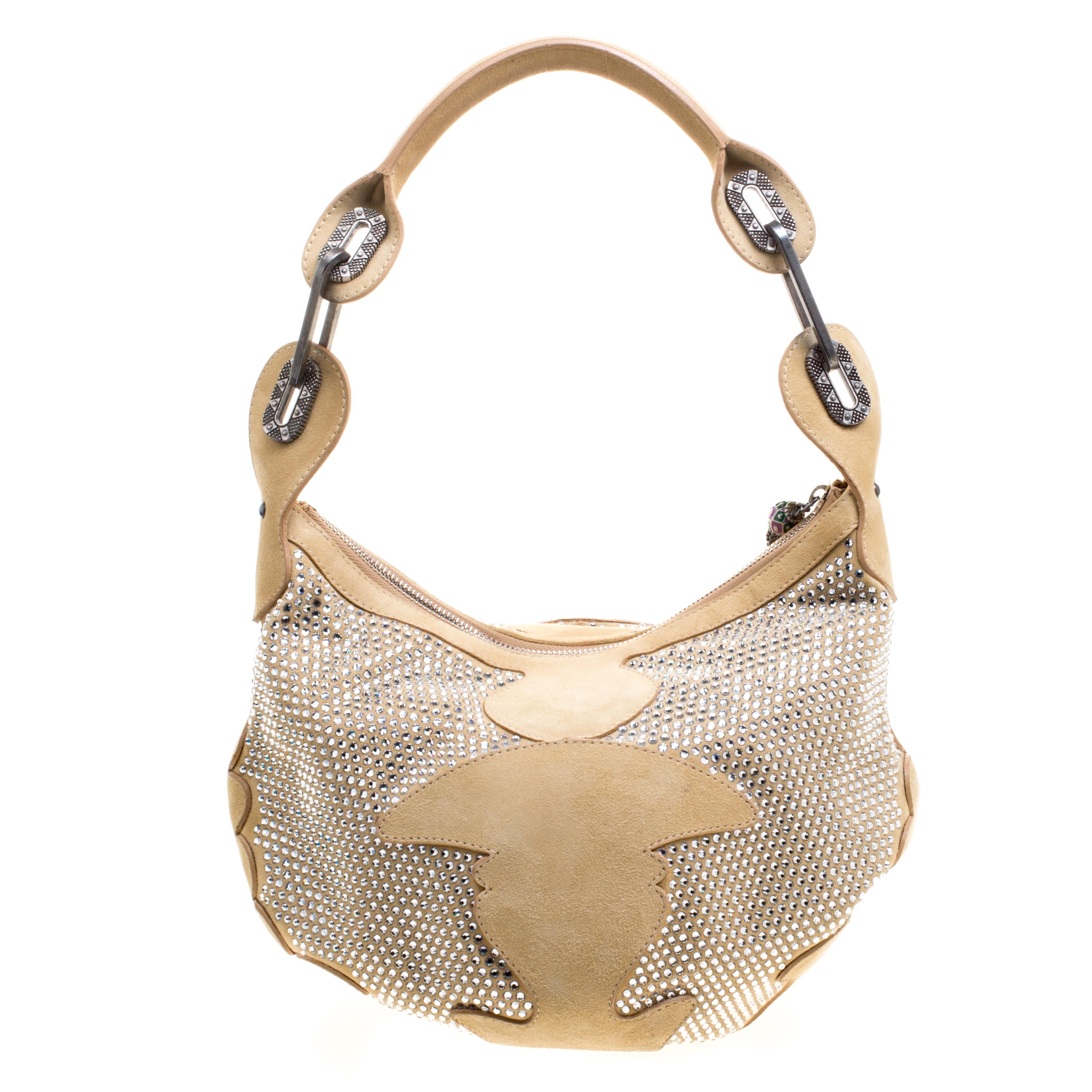 This Grant Hobo from the house of Jimmy Choo is designed in a light brown suede body with Swarovski embellishment all over. It comes with a top zipper closure and fitted with a uniquely designed shoulder strap. This chic bag can easily hold all your
