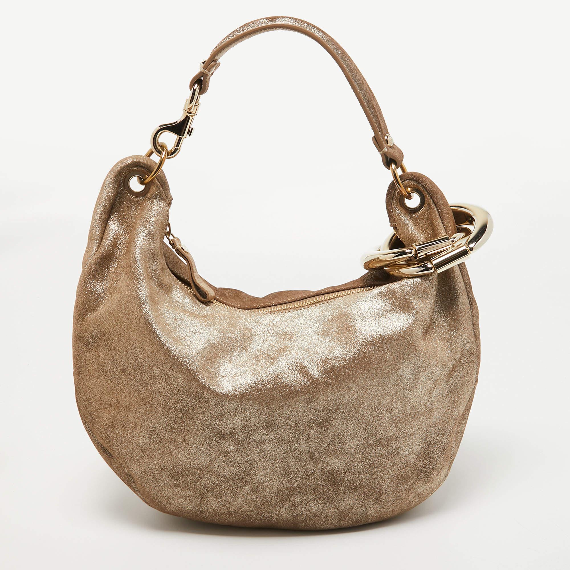 This stylish bag from Jimmy Choo has been crafted from suede. The top opens to a capacious interior that can easily hold your everyday essentials. The bag is finished with gold-tone hardware and a single handle.

Includes: Original Dustbag,