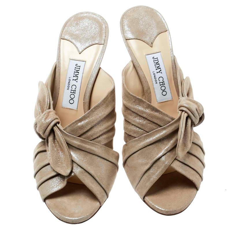 Designed purposely for fashion queens like you, these Jimmy Choo slides are soul-crushingly gorgeous! From their shape to their metallic beige textured suede body, these slides will bring you the best experience. They feature knotted bows,
