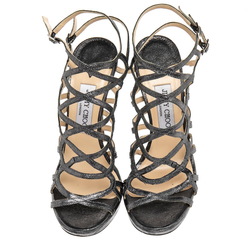 Express your inner confidence with these chic gladiator sandals designed by Jimmy Choo. They are created with metallic black leather and have a buckle-type closure. They are completed with 12.5 cm slender heels. Let your feet experience the comfort