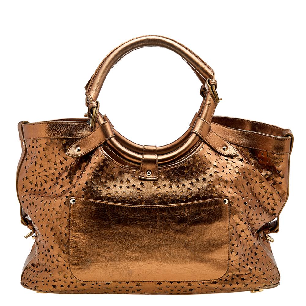 This satchel by Jimmy Choo is crafted from laser-cut leather in a metallic bronze shade. An Alcantara compartment, back pocket, two handles, and gold-tone hardware complete it. This bag works well for all occasions.

