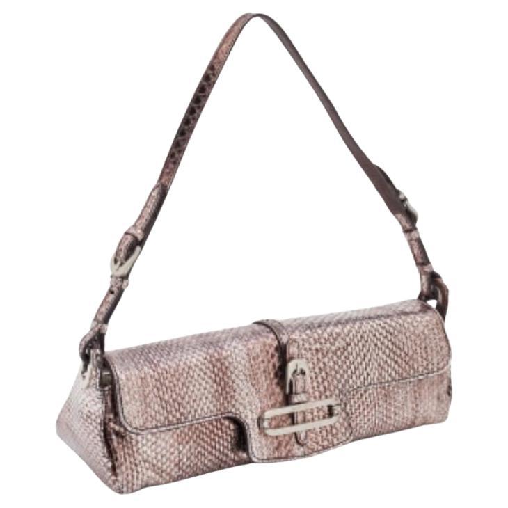 This Jimmy Choo Tulita bag represents the label's contemporary and classy attributes. It is made from snakeskin leather in a classy metallic brown and is complemented with silver-tone hardware. The bag is complete with a single handle.