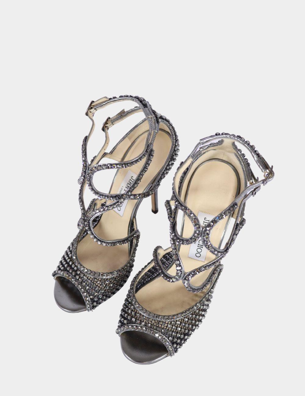 Sandalias Jimmy Choo con adornos metálicos, silueta con puntera abierta, adornos de cristal y tiras abrochadas en el tobillo.

Material: cuero y malla
Talla: EU 38 
Tacón: 11 cm
Estado general: Bueno
Estado interior: Signos de uso
Estado exterior: