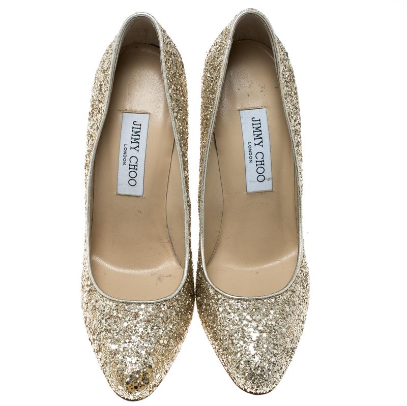 Add a sign of glamour to your look by slipping into this pair of sparkling metallic gold pumps. They are covered in coarse glitter, shaped as almond toes and balanced on 12.5 cm heels. Look gorgeous in this pair of Jimmy Choo pumps.

Includes: Info