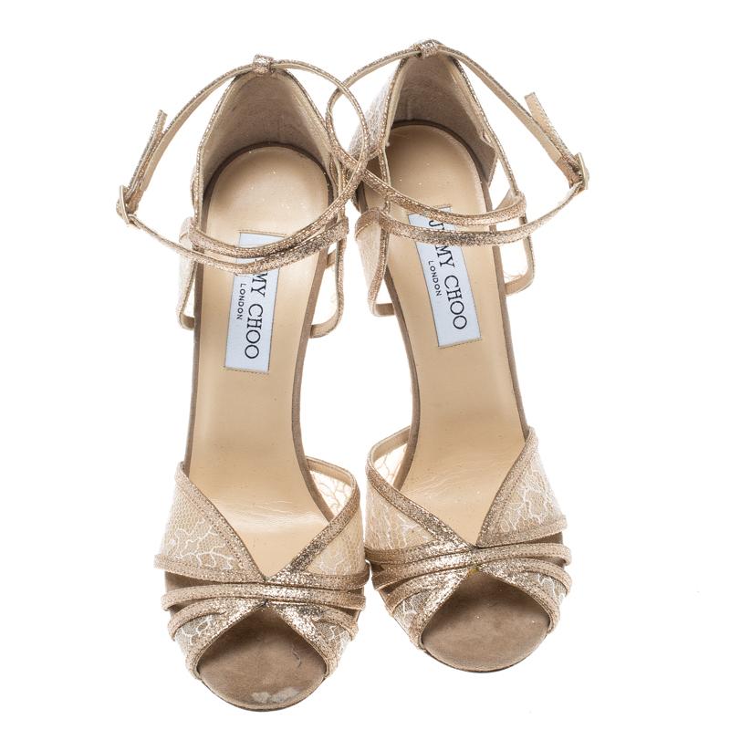 Breathtakingly beautiful and very elegant, these Fitch sandals from Jimmy Choo are all you need to make heads turn! Shimmering in metallic gold and crafted from a combination of glitter, mesh and lace, these sandals feature an open toe silhouette