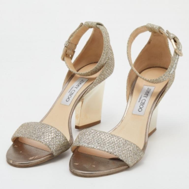 Haz una declaración de estilo estelar adornando estas sandalias Jimmy Choo. Creados con purpurina dorada metalizada, se combinan con una tira en los empeines, cierre de hebilla en el tobillo y contrafuerte cubierto. Los tacones de 12 cm de este par